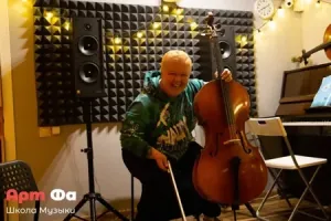 Взрослая ученица обнимает виолончель и смеётся во весь голос – Творческий вечер класса виолончели, май 2023